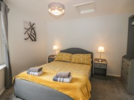 A bedroom with a bed and nightstand at Courtyard Cottage 