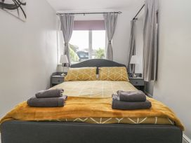 A bedroom with a bed and bedside tables at Courtyard Cottage