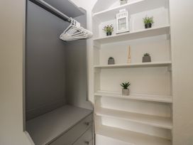 A closet with shelves and storage drawers at Courtyard Cottage