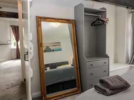 A mirror and wardrobe in a bedroom at Courtyard Cottage