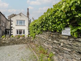 Exterior view of Courtyard Cottage with a stone wall and ivy in 