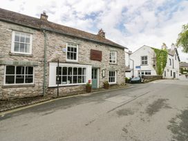 A stone building with windows and a sign on the street at Courtyard Cottage 