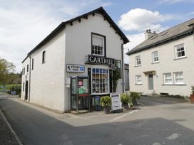 A street view of a building with a sign in Cartmel