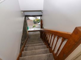 A staircase with wooden handrail and window at Courtyard Cottage in Cartmel