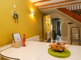 A dining room with a table and bottle at Courtyard Cottage in Cartmel