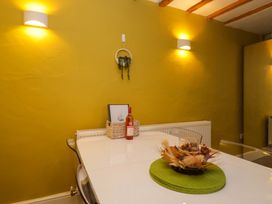 A dining room with a table and a wine bottle at Courtyard Cottage in Cartmel