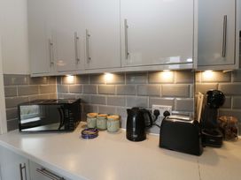 A kitchen with appliances including a microwave, kettle, toaster, and coffee machine at Courtyard Cottage, Cartmel