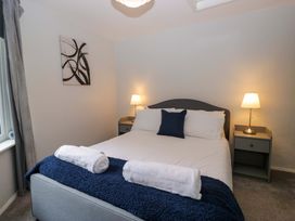 A bedroom with a bed and bedside lamps at Courtyard Cottage in Cartmel