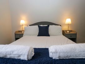 A bedroom with a bed and lamps at Courtyard Cottage in Cartmel