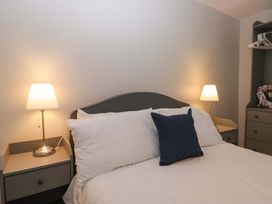 A bedroom with a bed and bedside lamps at Courtyard Cottage in Cartmel