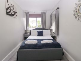 A bedroom with a bed and bedside tables at Courtyard Cottage Cartmel
