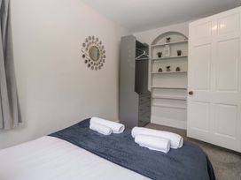 A bedroom with a bed and towels on it at Courtyard Cottage in Cartmel