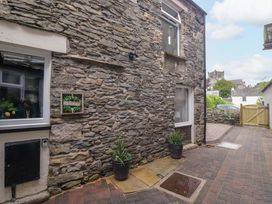 An outdoor area with a stone wall and plants at Courtyard Cottage in Cartmel