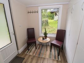 An entrance with two chairs and a table at Mayfly Cottage