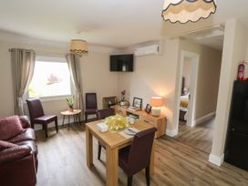 A living room with a sofa and table at Mayfly Cottage 