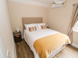 A bedroom with a bed and nightstand at Mayfly Cottage