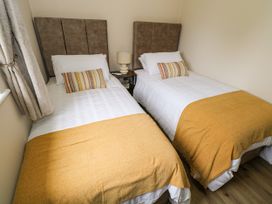 A bedroom with two single beds at Mayfly Cottage