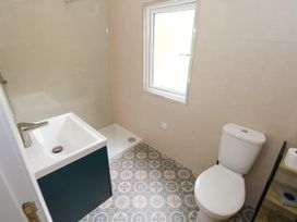 A bathroom featuring a shower, toilet, and washbasin at Mayfly Cottage
