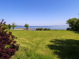 A view of a lake and grassy area at Mayfly Cottage