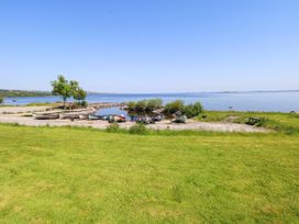 A shoreline with boats and trees at Mayfly Cottage in 