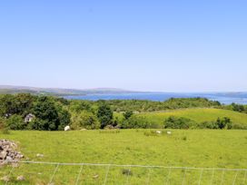 A landscape view with hills and a lake at Mayfly Cottage in 