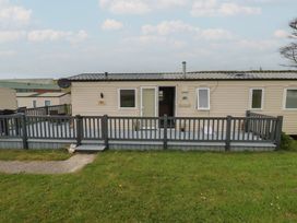 A caravan with a deck and steps at Tucked Away in Newquay