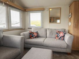 A living room with a sofa and cushions at Tucked Away in Newquay