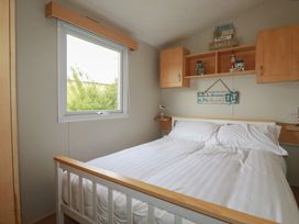 A bedroom with a bed and shelf at Tucked Away in Newquay