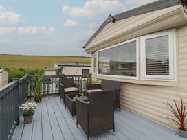 A deck area with chairs and table at Tucked Away in Newquay