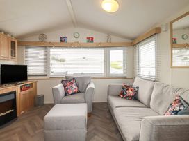 A living room with a sofa and television at Tucked Away in Newquay