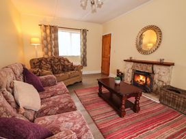 A living room with a sofa and a fireplace at Golf Club View in County Clare