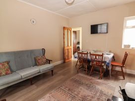 A living room with a dining area and a television at Golf Club View in County Clare