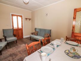 A dining room with a table and chairs at Golf Club View, County Clare