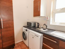 A kitchen with appliances including a washing machine and a microwave at Golf Club View, County Clare