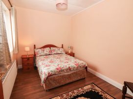 A bedroom with a bed and nightstand at Golf Club View, County Clare