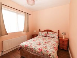 A bedroom with a bed and bedside table at Golf Club View, County Clare