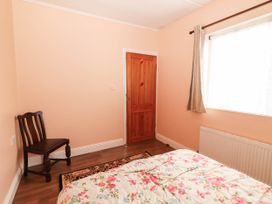 A bedroom with a bed and a chair at Golf Club View, County Clare
