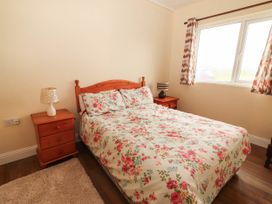A bedroom with a bed and bedside table at Golf Club View in County Clare