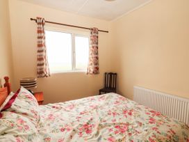 A bedroom with a bed and window at Golf Club View, County Clare