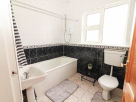 A bathroom with a bathtub and sink at Golf Club View, County Clare