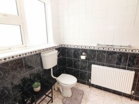 A bathroom with a toilet, radiator, and window at Golf Club View in County Clare