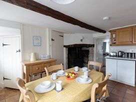 A kitchen with a dining table and chairs at Little Wickers in Wareham