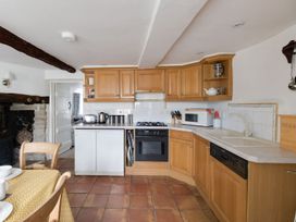 A kitchen with wooden cabinets and appliances at Little Wickers in Wareham