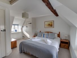 A bedroom with a bed and a window at Little Wickers Wareham