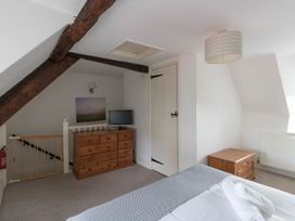 A bedroom with a bed and dresser at Little Wickers in Wareham