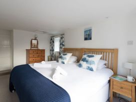 A bedroom with a bed and dresser at Little Wickers in Wareham