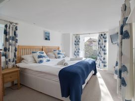 A bedroom with a bed and curtains at Little Wickers in Wareham