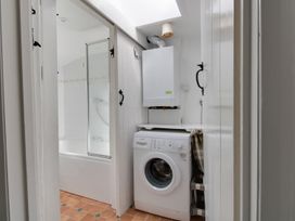 A bathroom with a washing machine and a shower at Little Wickers in Wareham