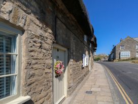 A stone wall with a door and window on the side of a street at Little Wickers in Corfe Castle