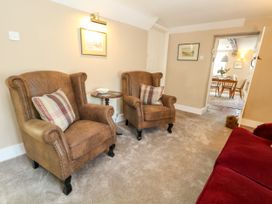 A living room with armchairs and a dining area at Little Wickers Corfe Castle